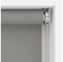 Šedá roleta s řetízkovým mechanismem v okenním rámu