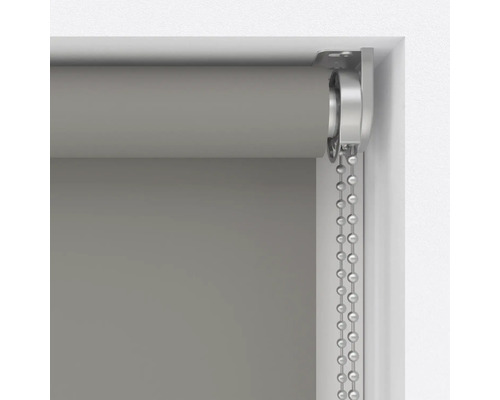 Šedá roleta s řetízkovým mechanismem v okenním rámu