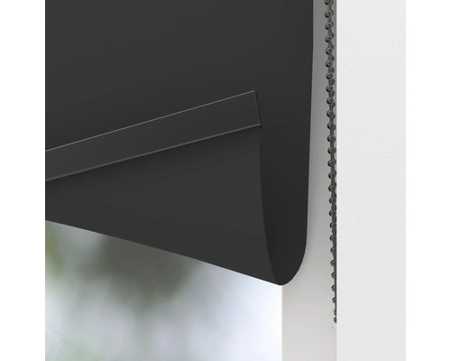 Detailní záběr černé rolety s řetízkovým ovládáním pro zatemnění oken.