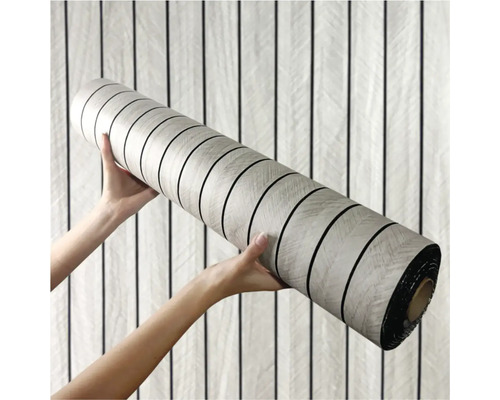 Role vinylové podlahy držená dvěma rukama.