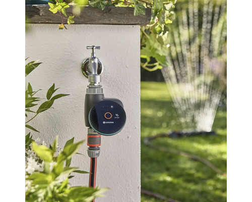 Řídicí jednotka zavlažování Gardena Smart Water Control na vodovodním kohoutku se zahradní hadicí a zavlažovačem trávníku