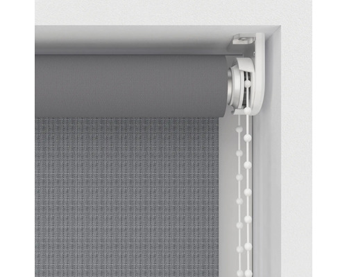 Šedá roleta s řetízkovým ovládáním v okenním rámu