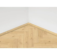 Roh s laminátovou podlahou ve vzoru rybí kosti a čtvrtkruhovou rohovou lištou na stěně.