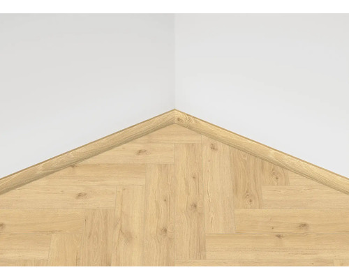 Roh s laminátovou podlahou ve vzoru rybí kosti a čtvrtkruhovou rohovou lištou na stěně.