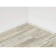 Položená laminátová podlaha s podlahovou lištou u zdi