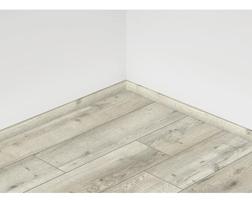 Položená laminátová podlaha s podlahovou lištou u zdi