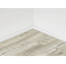 Rohový pohled na místnost se světlou laminátovou podlahou v dřevěném vzhledu a bílými stěnami