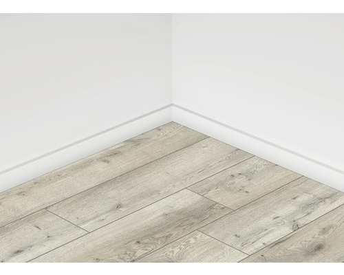 Rohový pohled na místnost se světlou laminátovou podlahou v dřevěném vzhledu a bílými stěnami