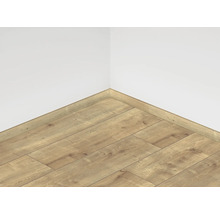 Položená laminátová podlaha s odpovídající soklovou lištou u stěny místnosti