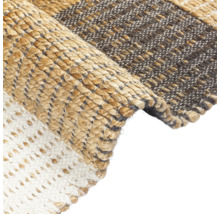 Detailní pohled na koberec s různými vzory tkaní a materiály