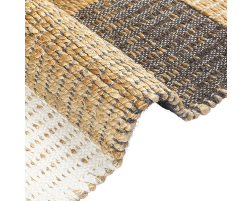 Detailní pohled na koberec s různými vzory tkaní a materiály