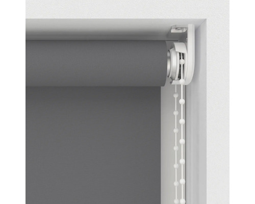 Šedá roleta s řetízkovým ovládáním v okenním rámu.