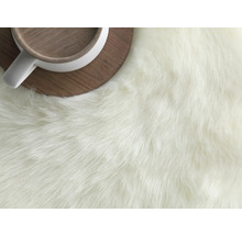 Detail koberce s dlouhým vlasem a šálku na podložce