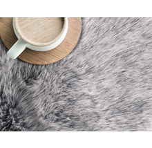 Šedý koberec s vysokým vlasem a šálek