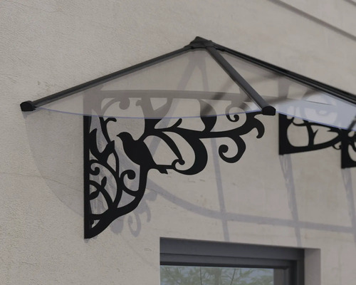 Vchodová stříška s průhlednou krytinou a ozdobnými černými nástěnnými držáky s motivem ptáků a listů.