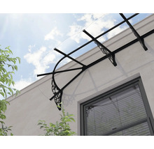 Vchodová stříška s průhlednou střechou a ozdobnými černými kovovými konzolami nad oknem.