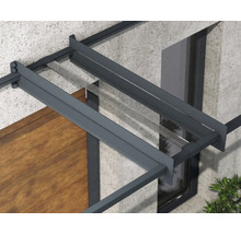 Detail vchodové stříšky s antracitovým hliníkovým rámem a průhlednou skleněnou výplní na fasádě domu.