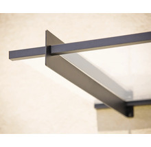 Detailní pohled na moderní vchodovou stříšku s černým kovovým rámem a skleněnou tabulí.