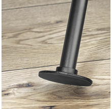 Detailní záběr černé nohy nábytku s patkou na dřevěné podlaze.