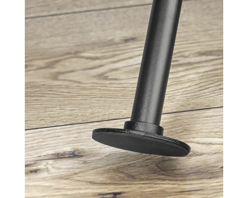 Detailní záběr černé nohy nábytku s patkou na dřevěné podlaze.