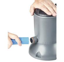 Osoba připojuje hadici k bazénovému čerpadlu.