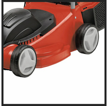 Detail červené sekačky na trávu s černými a bílými prvky.