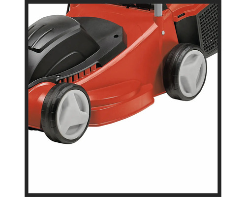 Detail červené sekačky na trávu s černými a bílými prvky.