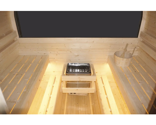 Interiér sauny s dřevěnými lavicemi, saunovými kamny a dřevěným vědrem s naběračkou