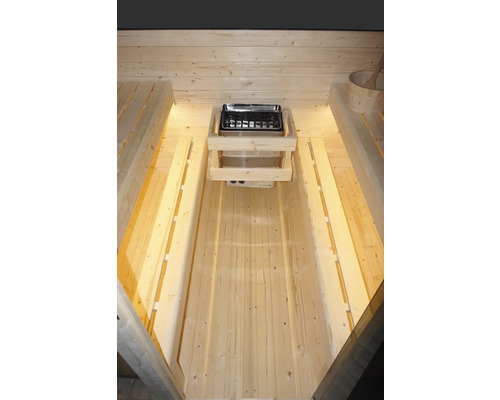 Vnitřní pohled na saunu se saunovými kamny a dřevěnými lavicemi