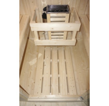 Interiér sauny s kamny na dřevo a lamelovým roštem