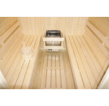 Interiér sauny s dřevěnými lavicemi, kamny a dřevěným vědrem