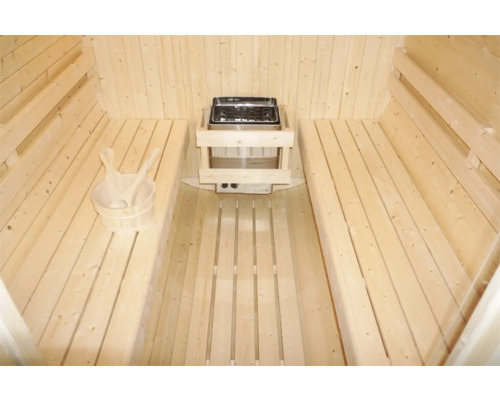 Interiér sauny s dřevěnými lavicemi, kamny a dřevěným vědrem