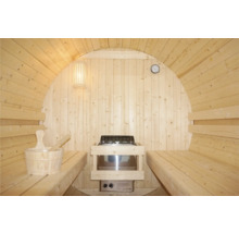 Vnitřní pohled na sudovou saunu s lavicemi, kamny, lampou, hodinami a saunovým kbelíkem s naběračkou