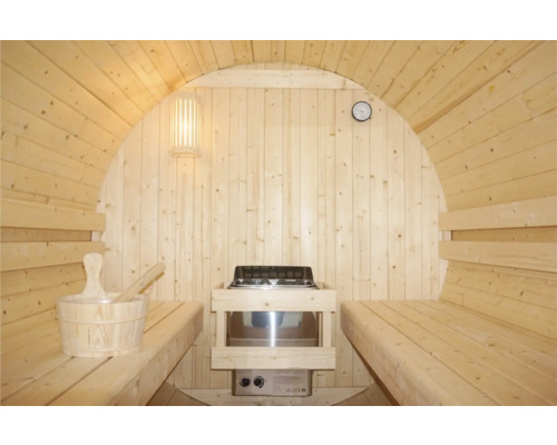 Vnitřní pohled na sudovou saunu s lavicemi, kamny, lampou, hodinami a saunovým kbelíkem s naběračkou