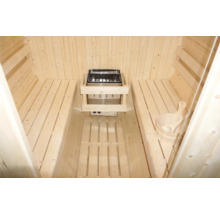 Vnitřní pohled na saunu s dřevěnými lavicemi, saunová kamna a saunový kbelík s naběračkou.