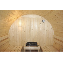 Vnitřní pohled na dřevěnou sudovou saunu s kamny, lavicemi, lampou a teploměrem