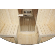 Vnitřní pohled na dřevěnou sudovou saunu s lavicemi a saunovými kamny