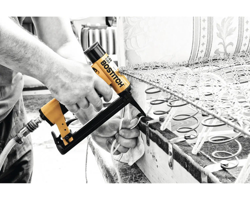 Osoba připevňuje pružiny k nábytku pomocí drátové sešívačky Bostitch.