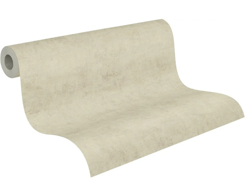 Částečně rozvinutá role béžové vliesové tapety se strukturou omítky.