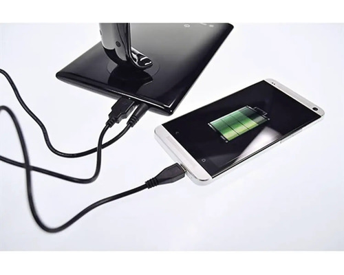 Smartphone se nabíjí pomocí USB kabelu v nabíjecí stanici.