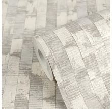 Vliesová tapeta s vertikálním proužkovaným vzorem v imitaci kamene nebo dřeva, světle šedá strukturovaná.