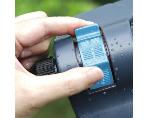 Ruka ovládá zavlažovač pro zavlažování zahrady