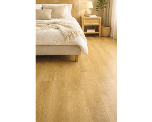 Ložnice se světle dřevěnou podlahou, postelí a nočním stolkem