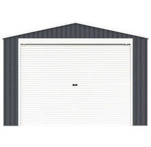 Kovová garáž v antracitové barvě se sedlovou střechou a širokými bílými rolovacími vraty.