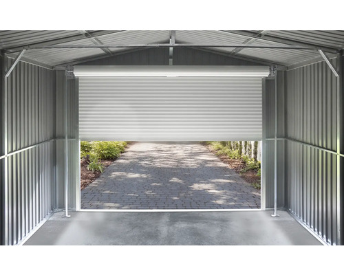 Vnitřní pohled na kovový domek na nářadí se stěnami z vlnitého plechu a pootevřenými rolovacími vraty s výhledem na dlážděnou cestu.