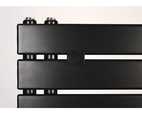 Detailní záběr na matně černý radiátor s plochými panely a vertikálními přípojkami.