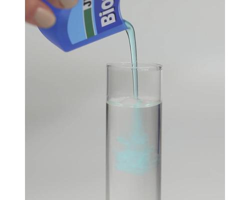 Modrá kapalina se nalévá z láhve do zkumavky naplněné vodou pro ukázku procesu míchání.