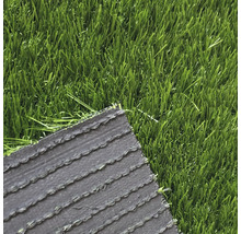 Detailní pohled na umělý trávník s viditelnou rubovou stranou a stébly.