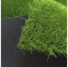 Detailní záběr na umělý trávník s hustými zelenými stébly a tmavou strukturovanou spodní stranou.