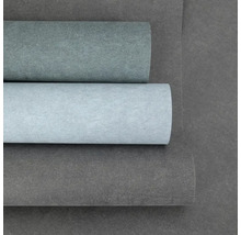 Vliesová tapeta ve vzhledu betonu se strukturovaným povrchem, tři role v různých odstínech šedé.